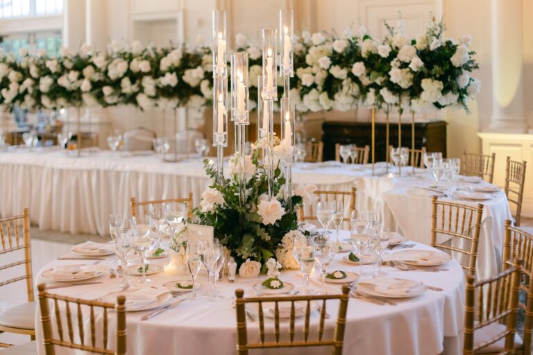 Tavolo tondo apparecchiato con candele e fiori per catering per matrimonio